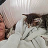 person, kitten, sleeping, blanket, bed, cozy, resting, animal, pet, indoor, comfort, cute, feline, fur, nap, relaxation, soft, domestic, young, companion