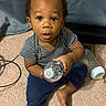 baby, child, toddler, sitting, carpet, indoors, portrait, face, wide_eyed, curious, water_bottle, baby_bottle, striped_shirt, blue_pants, barefoot, bedroom, furniture, floor, candid, home
