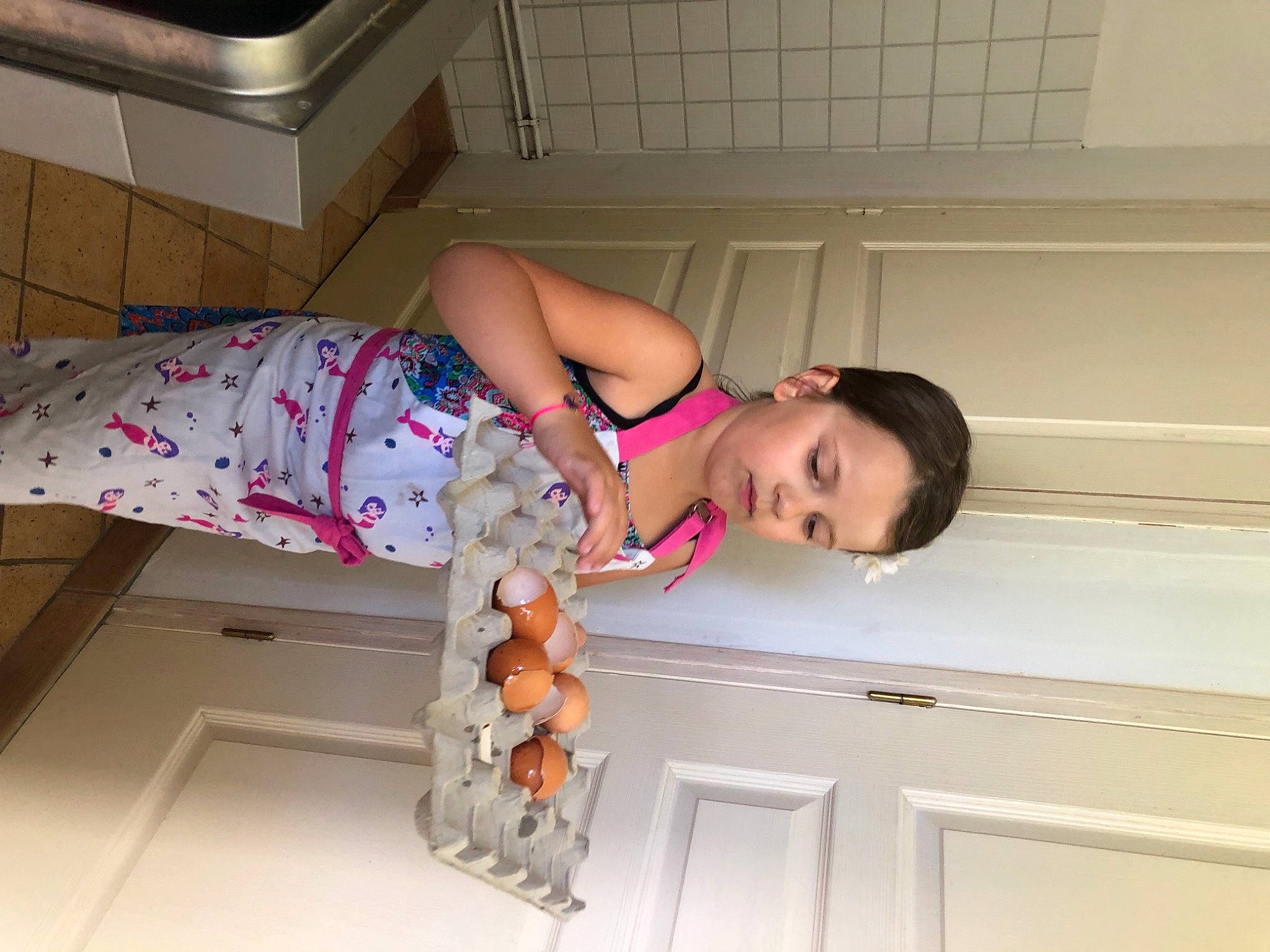 Iléana participe au concours pour gagner de l'argent avec cette photo : cabinetry, carton, child, comfort, flooring, fun, homemaker, human_leg, kitchen, leg, major_appliance, person, room, shipping_box, textile, thigh, toddler