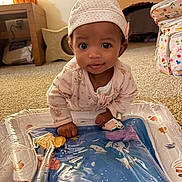 Lyric is registered to the contest to win money with this photo: baby, child, infant, sitting, portrait, wide_eyes, smiling, hat, pink_clothing, onesie, play_mat, inflatable_toy, indoor, home, carpet, diaper_bag, lamp, pumpkin, colorful, happy