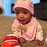 Lyric joined the competition — help win amazing prizes! baby, child, infant, portrait, sitting, carpet, indoor, pink_clothing, hat, bib, bear_design, toy, drum, colorful, wide_eyed, surprised, looking_at_camera, hands, home, close_up