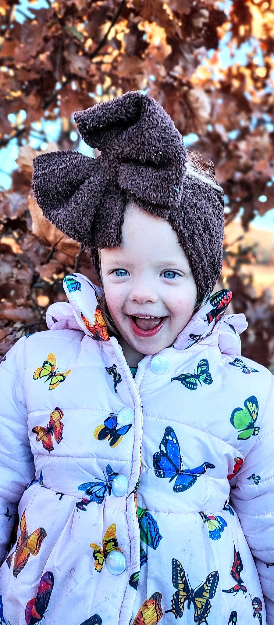 Aspen is registered to the contest to win money with this photo: cap, child, electric_blue, event, face, freezing, fun, fur, happy, head, headwear, knit_cap, outerwear, people_in_nature, person, photograph, sleeve, smile, toddler, tree