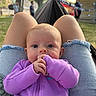 Andi is registered to the contest to win money with this photo: baby, infant, child, portrait, purple_clothing, hammock, outdoor, campsite, forest, grass, wooden_cabin, sitting, lying_down, hands, sleeve, wide_eyes, face, daylight, relaxed, family_outing