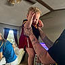 Josiah joined the competition — help win amazing prizes! child, toddler, baby, being_held, indoor, living_room, ceiling_fan, family, adult, tattoo, red_outfit, blue_shirt, white_shorts, socks, shoes, furniture, window, curtains, playroom, motion_blur