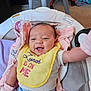baby, smiling, bib, yellow_bib, baby_seat, blanket, indoor, happy, infant, clothing, blue_pants, pink_blanket, face, person, child, cute, young, seat, comfort, home