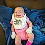 baby, smiling, pink_onesie, mittens, bib, blue_blanket, couch, infant, happy, cute, indoors, polka_dot_socks, hand, face, person, child, soft_toys, cozy, relaxed, apparel