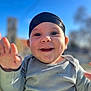 baby, child, smiling, happy, face, headband, outdoor, blue_sky, sunlight, portrait, clothing, hand, expression, cute, young, person, daylight, nature, background, cheerful