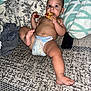baby, child, diaper, pizza, food, bed, pillow, blanket, hand, foot, face, expression, indoor, sleeping_area, clothing, person, messy, eating, curious, wide_eyes