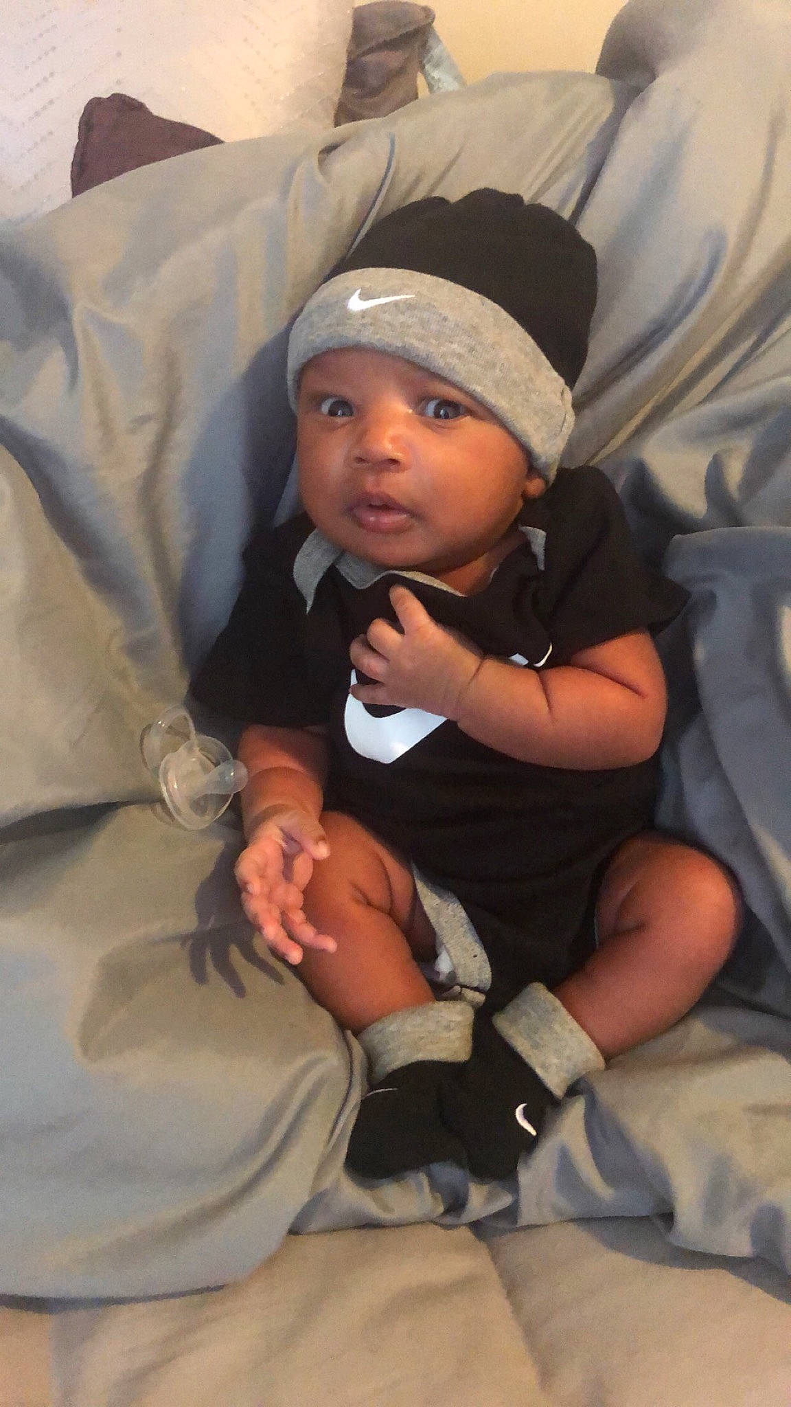 Jamari is registered to the contest to win money with this photo: baby, baby_products, baby_toddler_clothing, beanie, cap, child, comfort, eye, face, finger, fun, gesture, hand, hat, headwear, knit_cap, nail, person, sitting, skin