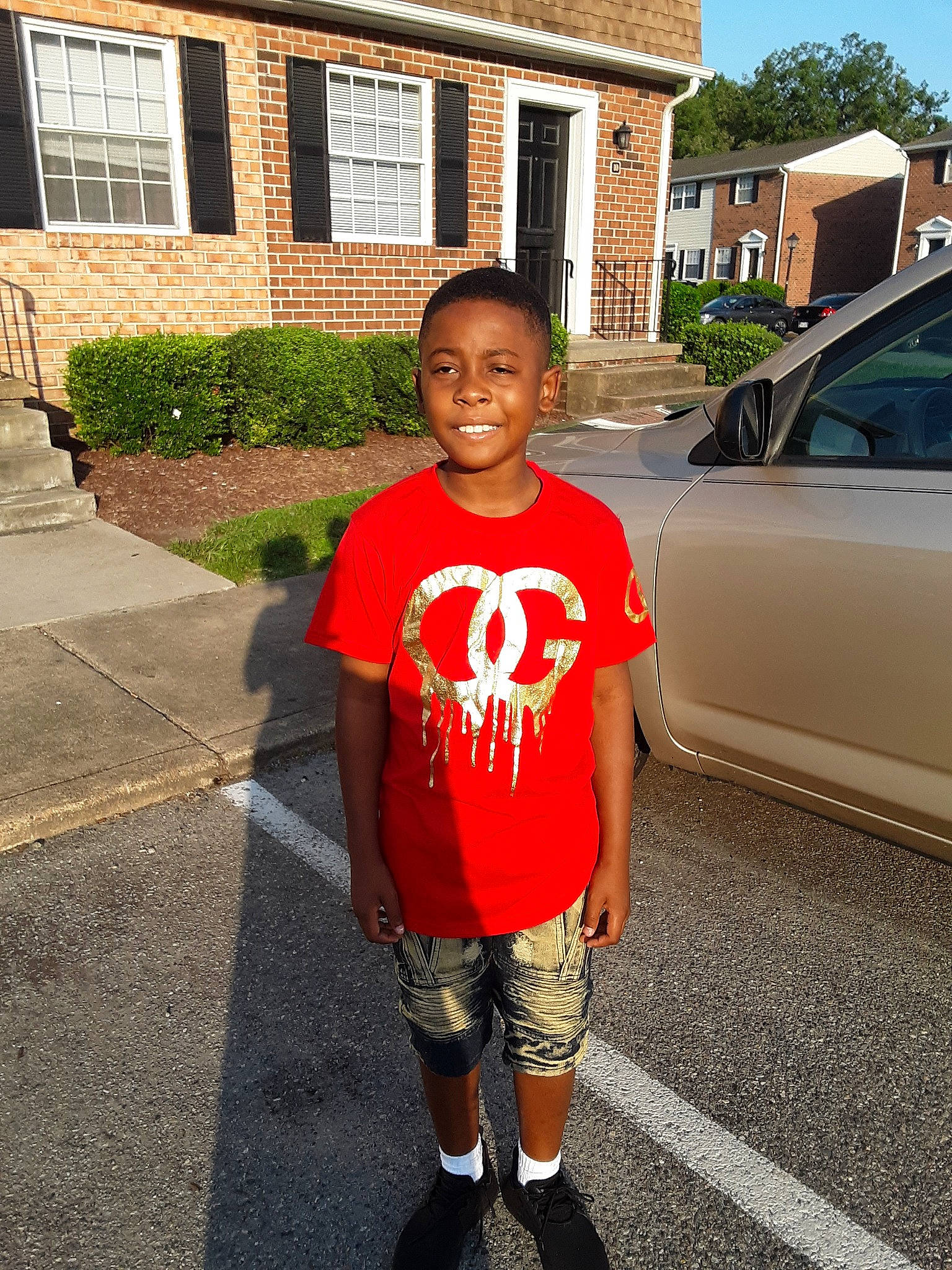 Jai is registered to the contest to win money with this photo: asphalt, car, child, cool, footwear, joint, joy, knee, leisure, person, photography, recreation, red, shoe, shoulder, snapshot, standing, style, summer, t_shirt