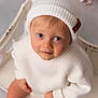 toddler, child, white_hat, white_sweater, beanie, bench, pink_flowers, portrait, indoor, cute, soft_lighting, smiling, baby, face, looking_up, hands, skin, cozy, warm, innocent