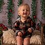 Camille participe au concours pour gagner de l'argent avec cette photo : baby, child, smiling, plaid_clothing, wooden_bed, fluffy_blanket, green_vines, red_berries, indoor, portrait, cute, happy, feet, toes, blond_hair, infant, decor, cozy, sitting, studio