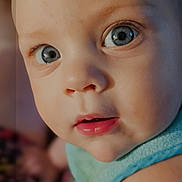 Corin joined the competition — help win amazing prizes! baby, child, face, blue_eyes, close_up, infant, skin, curious, portrait, app_icons, smartphone_screen, blurred_background, blue_outfit, head, expression, person, photography, indoors, human, mobile_phone