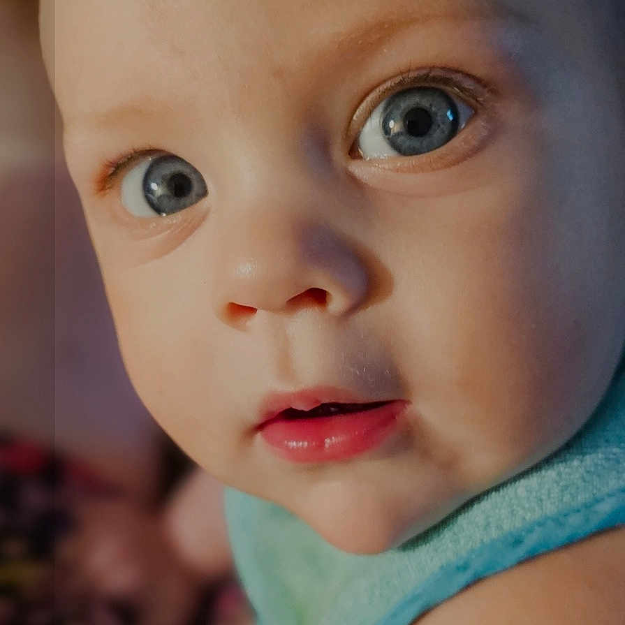 Corin joined the competition — help win amazing prizes! baby, child, face, blue_eyes, close_up, infant, skin, curious, portrait, app_icons, smartphone_screen, blurred_background, blue_outfit, head, expression, person, photography, indoors, human, mobile_phone