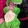 Malakai joined the competition — help win amazing prizes! baby, child, dinosaur_costume, green, onesie, hood, fist, blanket, patterned_blanket, hand, soft, cute, infant, clothing, lying_down, indoor, portrait, cozy, expression, person