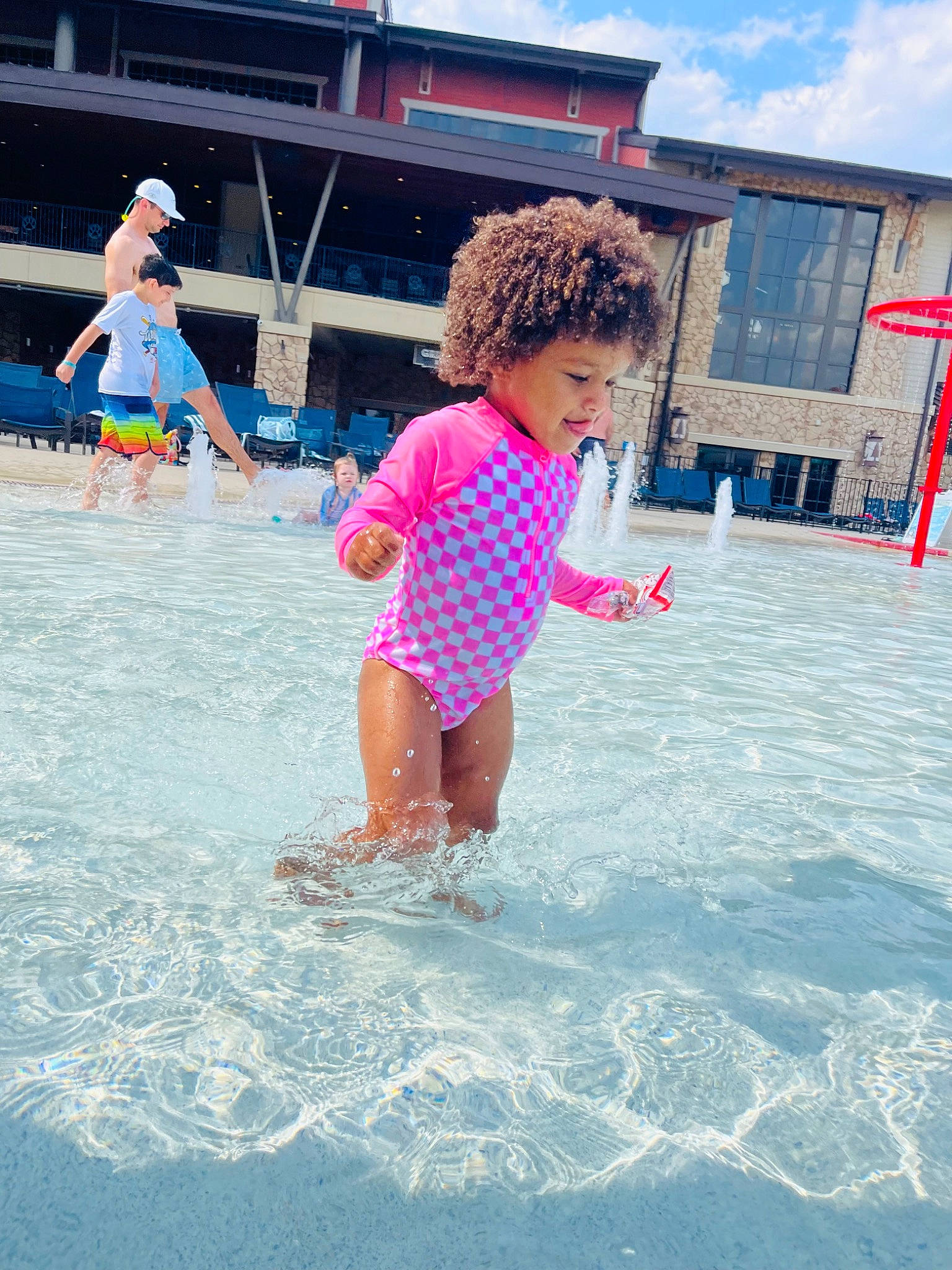 Arabella is registered to the contest to win money with this photo: aqua, azure, bathing, body_of_water, cloud, fun, happy, headwear, leisure, nonbuilding_structure, ocean, people_on_beach, person, personal_protective_equipment, play, recreation, sand, sky, swimming_pool, toddler