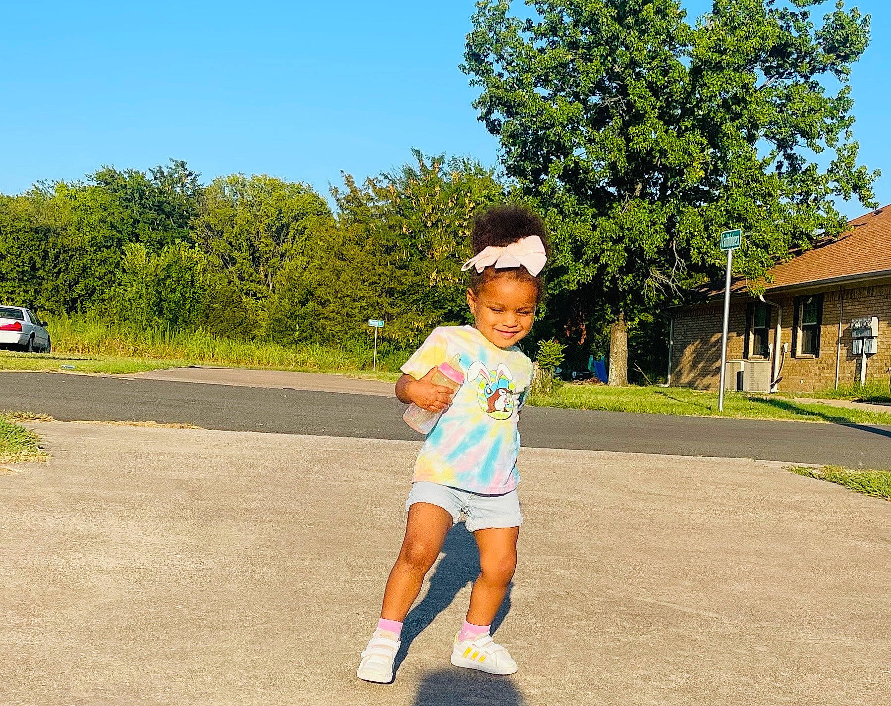 Arabella is registered to the contest to win money with this photo: asphalt, child, electric_blue, eyewear, fun, grass, hat, joy, landscape, leisure, person, plant, recreation, road, road_surface, running, shorts, sky, sun_hat, t_shirt