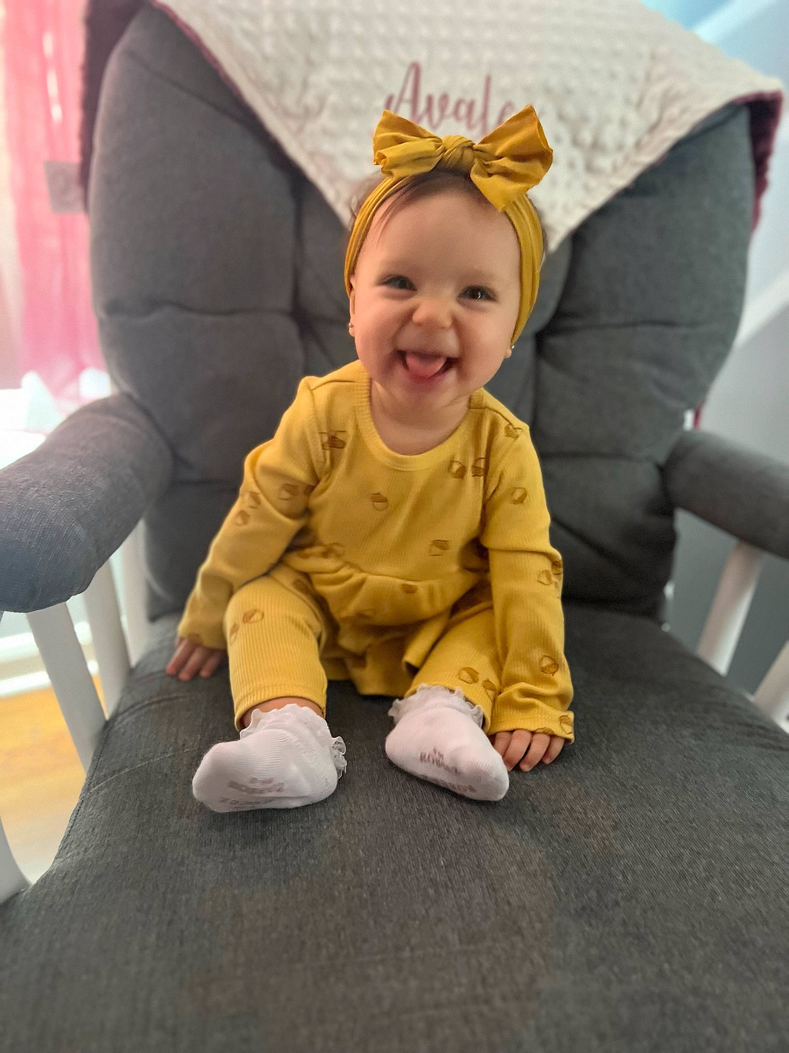 Avalee is registered to the contest to win money with this photo: baby, baby_toddler_clothing, child, comfort, costume_hat, eye, fashion_accessory, finger, flooring, fun, gesture, happy, head, joy, leg, person, room, sitting, sleeve, smile