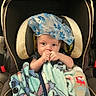 baby, car_seat, blanket, bottle, child, infant, blue, floral, cloth, cute, face, person, indoors, seat, toy, comfort, young, holding, expression, cozy