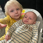 Jameson joined the competition — help win amazing prizes! baby, toddler, child, siblings, brother, onesie, striped_clothing, yellow_pajamas, blonde_hair, indoor, couch, baby_seat, carpet, face, hand, looking_at_camera, cute, family, portrait, home