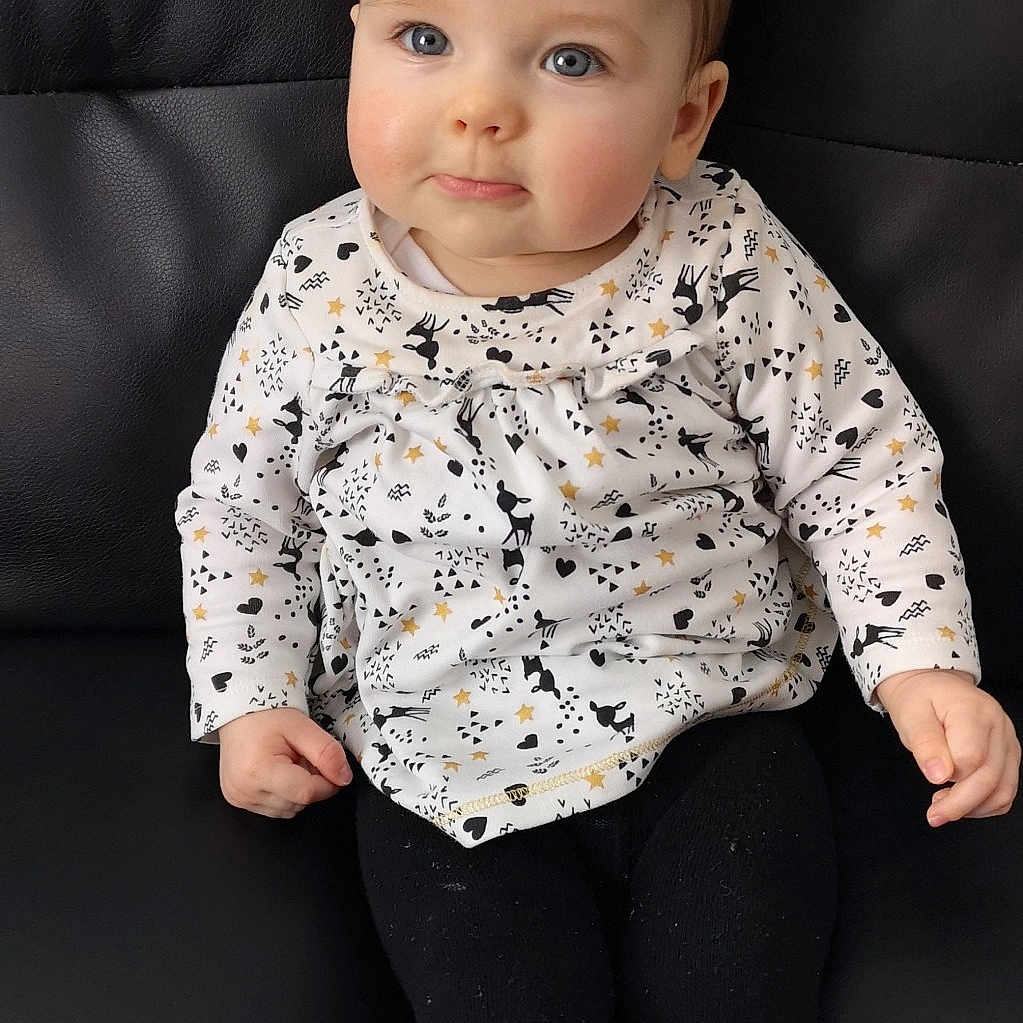 Emma participe au concours pour gagner de l'argent avec cette photo : baby, baby_toddler_clothing, cheek, child, child_model, eye, face, head, iris, lip, outerwear, pattern, person, photo_shoot, photography, portrait_photography, sitting, skin, sleeve, standing