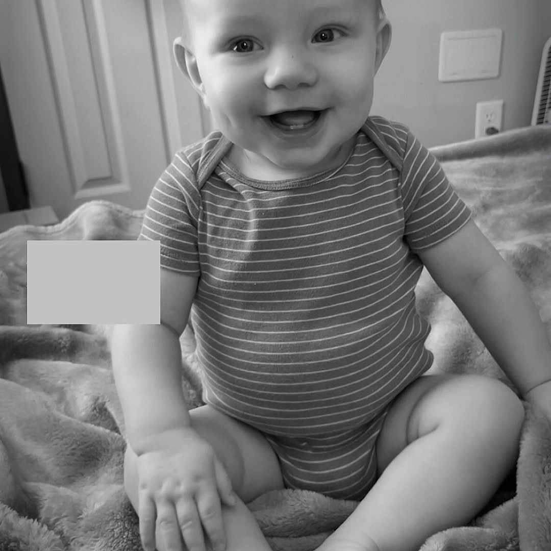 Karson joined the competition — help win amazing prizes! baby, black_and_white, blanket, child, clothing, cozy, cute, foot, hand, happy, indoor, infant, monochrome, onesie, portrait, room, sitting, smiling, soft, texture