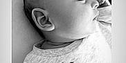 Theo is registered to the contest to win money with this photo: baby, sleeping, black_and_white, infant, face, profile, clothing, text_embroidery, soft_light, cozy, peaceful, portrait, child, newborn, closeup, cute, resting, fabric, head, ear