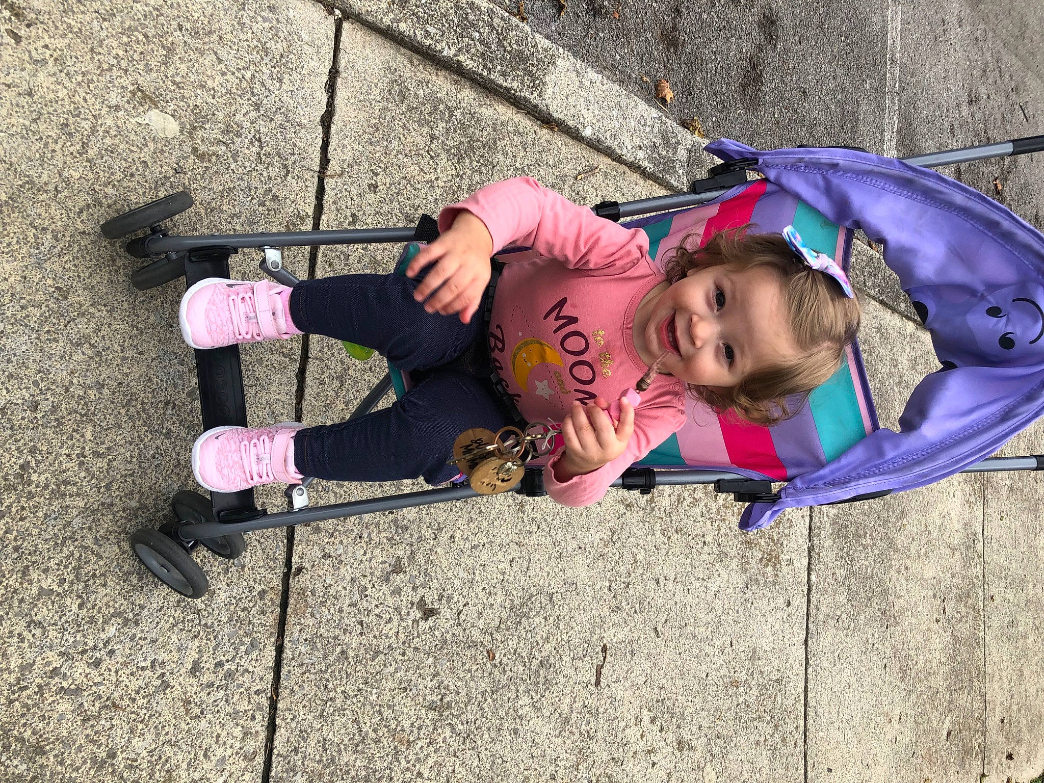 Ava is registered to the contest to win money with this photo: asphalt, boot, child, electric_blue, fashion_accessory, fun, grass, human_leg, jacket, joy, leisure, magenta, outdoor_shoe, person, pink, recreation, road_surface, shoe, sidewalk, smile