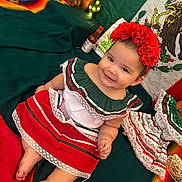 Hailey is registered to the contest to win money with this photo: baby, blanket, celebration, child, colorful, cultural, decorations, green, happy, headband, indoors, infant, mexican_flag, portrait, red, red_flower, sitting, smile, traditional_clothing, white