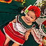 baby, blanket, celebration, child, colorful, cultural, decorations, green, happy, headband, indoors, infant, mexican_flag, portrait, red, red_flower, sitting, smile, traditional_clothing, white