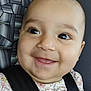baby, car_seat, child, closeup, clothing, cute, eyes, face, floral_pattern, hand, happy, head, indoors, infant, person, portrait, safety, seatbelt, sitting, smiling