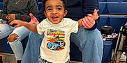 Zander is registered to the contest to win money with this photo: toddler, child, woman, people, indoor, gymnasium, bleachers, casual_clothing, jeans, sneakers, smile, happy, supporting, spectators, headband, glasses, floor, seating, wheelchair, adult