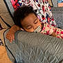 Zaniah joined the competition — help win amazing prizes! baby, sleeping, pacifier, pajamas, floral_pattern, armrest, quilted, blanket, sofa, indoor, child, resting, peaceful, cozy, hand, face, curly_hair, carpet, fabric, home