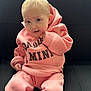 Olivia is registered to the contest to win money with this photo: baby, infant, child, pink_hoodie, hoodie, sweatshirt, sofa, couch, portrait, sitting, looking_at_camera, blue_eyes, blonde_hair, cute, hand, clothing, indoor, soft_lighting, smile, close_up