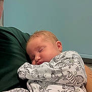 Olivia is registered to the contest to win money with this photo: arm, baby, calm, child, close_up, comfort, cute, face, gentle, holding, indoor, infant, pajamas, peaceful, person, rest, sleeping, soft_lighting, toddler, zebra_pattern