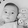 baby, bed, black_and_white, blanket, child, closeup, cute, expression, eyes, face, heart, indoors, infant, newborn, portrait, sleepwear, soft_toy, stuffed_animal, teddy_bear, text
