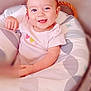 baby, smiling, child, infant, cushion, patterned, heart, clothing, happy, face, blue_eyes, sitting, indoor, soft_light, cute, young_child, portrait, cozy, pillow, comfortable
