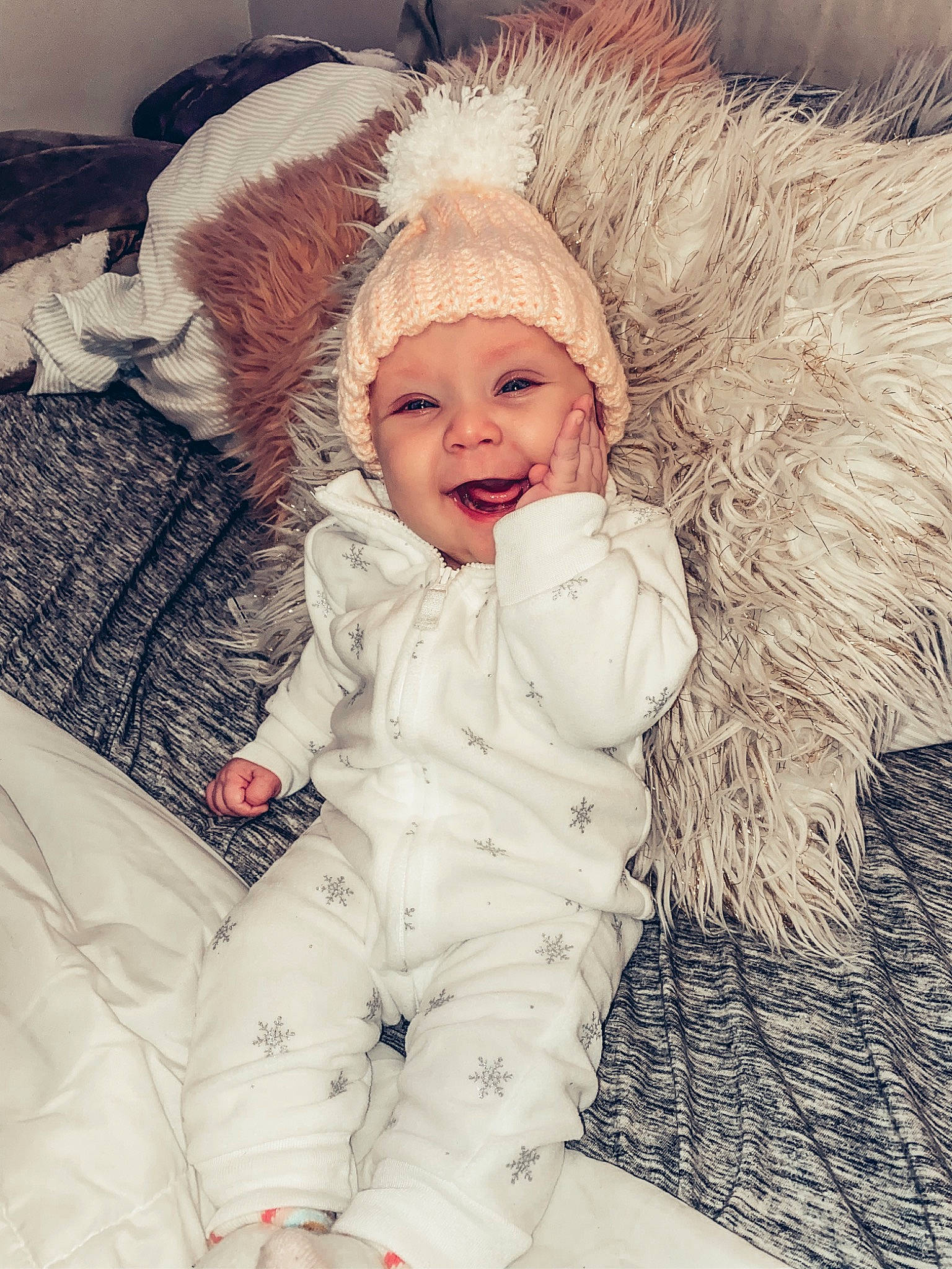 Graelyn is registered to the contest to win money with this photo: animal_product, baby, baby_laughing, baby_toddler_clothing, bonnet, cheek, child, costume_accessory, fur, fur_clothing, headwear, human, mouth, natural_material, nightwear, nose, overall, person, playing_with_kids, toddler