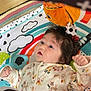 Alaina is registered to the contest to win money with this photo: baby, infant, play_mat, plush_toy, colorful, rainbow, cloud, patterned_clothing, floral, animal_print, cute, child, indoor, soft_toy, happy, curious, portrait, baby_girl, lying_down, early_childhood