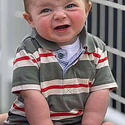 Andrew is registered to the contest to win money with this photo: baby, child, infant, smiling, sitting, striped_shirt, polo_shirt, white_socks, wooden_bench, outdoor, fence, cute, face, hands, legs, blue_eyes, short_hair, skin, expression, portrait