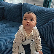 Lea a rejoint le concours — aidez-le/la à gagner de superbes lots ! baby, infant, child, pajamas, blue_couch, curious, indoors, sitting, plush, soft_furniture, cute, wide_eyes, small_hands, white_clothing, decor, home, window, curtains, portrait, young_kid
