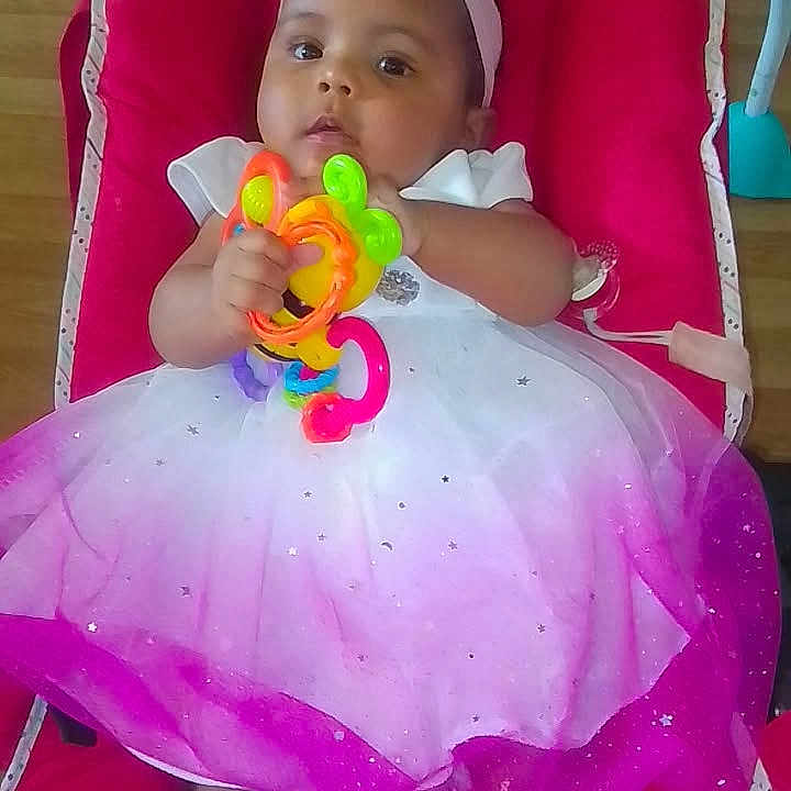 Lynda a rejoint le concours — aidez-le/la à gagner de superbes lots ! baby, barefoot, bow, chair, child, colorful, cushion, cute, dress, floor, girl, headband, indoors, infant, plastic, portrait, rings, sitting, toy, wooden_floor