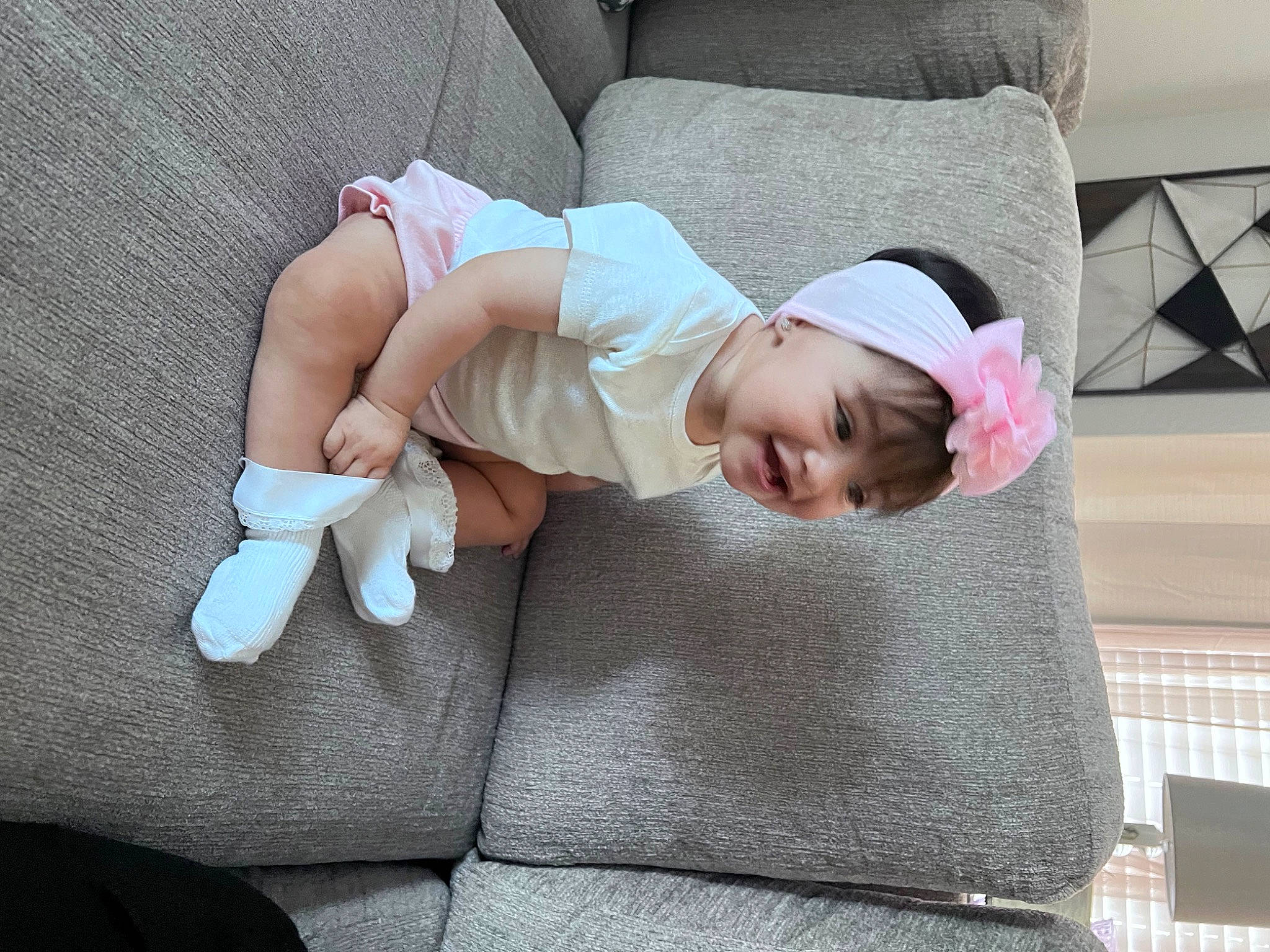 Aubrey joined the competition — help win amazing prizes! baby, baby_products, baby_toddler_clothing, child, comfort, couch, facial_expression, finger, foot, hat, headwear, human_leg, lap, leg, linens, person, sitting, sleeve, sock, thigh