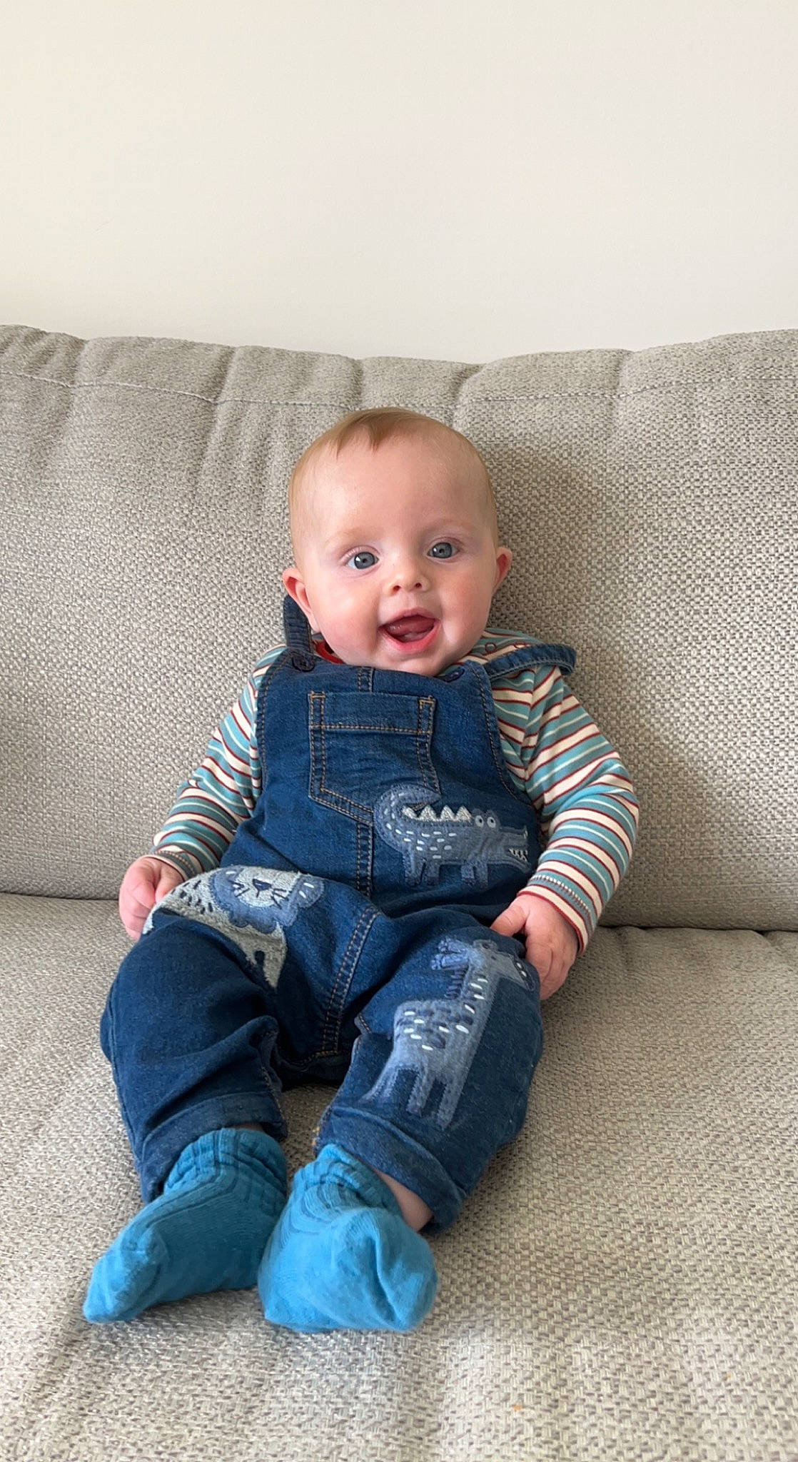 Joey is registered to the contest to win money with this photo: baby, baby_toddler_clothing, cheek, comfort, couch, eye, face, flash_photography, flooring, grey, hair, head, pattern, person, product, skin, sleeve, smile, surprise, t_shirt