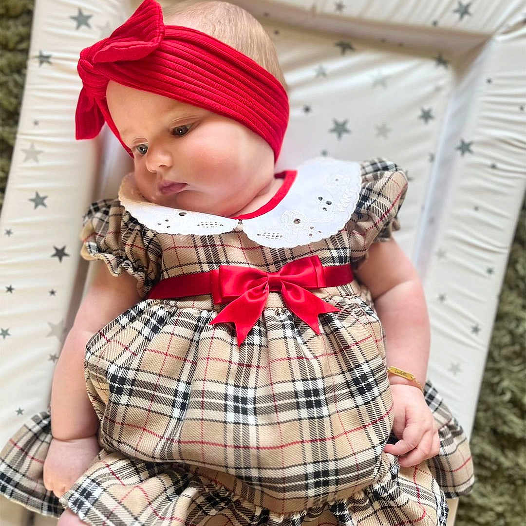 Isabella is registered to the contest to win money with this photo: accessories, baby, blanket, bonnet, clothing, costume, cushion, face, furniture, hair, hat, head, homedecor, infantbed, newborn, person, photography, portrait, sitting, sleeve