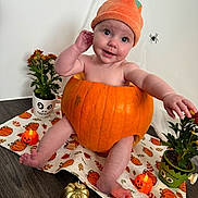 Harper is registered to the contest to win money with this photo: baby, pumpkin, halloween, hat, plant, flowerpot, candle, floor, orange, child, cute, decorations, holiday, smiling, face, indoor, tablecloth, toy, spooky, costume