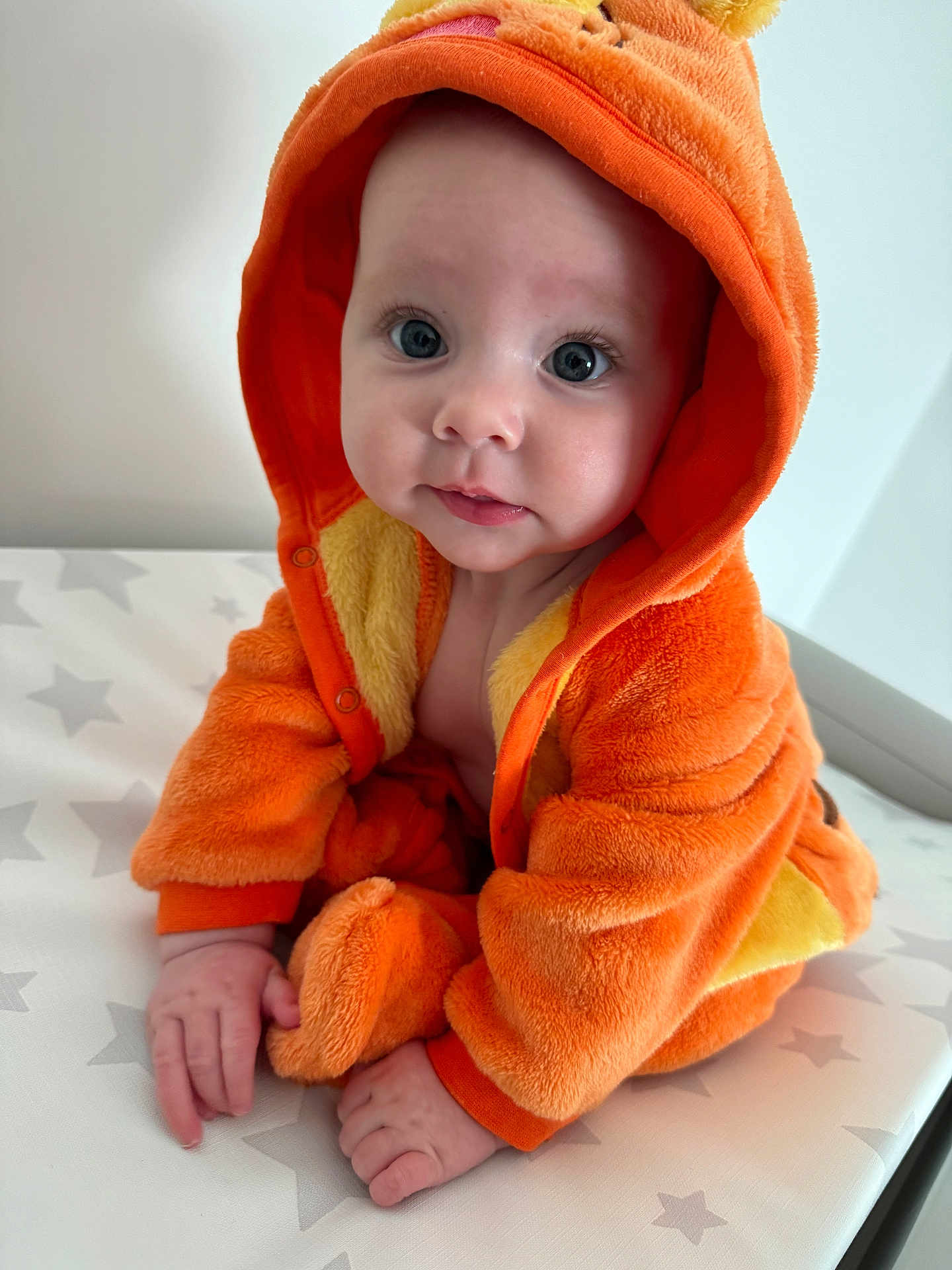 Harper joined the competition — help win amazing prizes! baby, infant, hooded_clothing, orange_clothing, onesie, cute, child, portrait, indoor, soft_texture, star_pattern, sitting, hands, face, eyes, expression, young_child, plush, warm_clothing, adorable