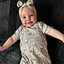 baby, infant, smiling, onesie, headband, bow, bunny_pattern, cute, lying_down, soft_blanket, chubby_cheeks, happy, portrait, child, clothing, face, skin, expression, young, indoors