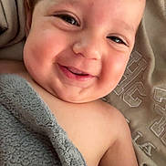 Kasen is registered to the contest to win money with this photo: baby, smiling, blanket, cozy, face, portrait, child, happy, skin, infant, cute, expression, closeup, lying_down, soft_texture, indoors, young, head, eyes, mouth