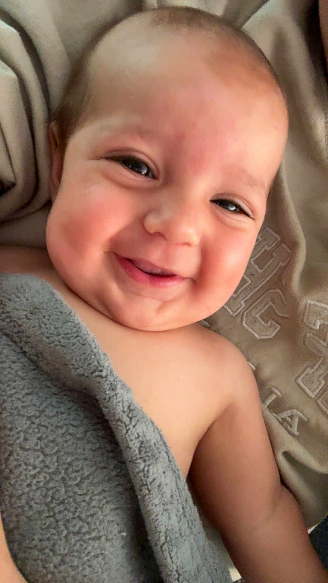 Kasen is registered to the contest to win money with this photo: baby, smiling, blanket, cozy, face, portrait, child, happy, skin, infant, cute, expression, closeup, lying_down, soft_texture, indoors, young, head, eyes, mouth